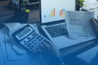 Pessoa analisando documentos financeiros com uma calculadora e um laptop mostrando gráficos, indicando a revisão de aposentadoria por um Advogado Previdenciário em Itapetininga.
